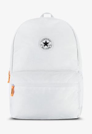 Biały plecak Converse z przednią kieszenią na zamek, pomarańczowymi suwakami i okrągłą czarną naszywką z logo gwiazdy na górze na środku.