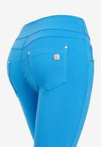 Leggings in denim blu brillante con una texture liscia, vita alta, due tasche posteriori e dettagli decorativi in hardware argentato.