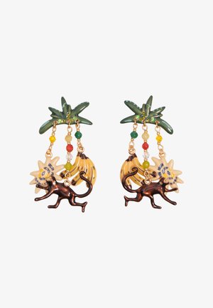 Pendientes con hojas de palma verdes, cuentas colgantes, plátanos amarillos, flores blancas y charms de mono de bronce sobre un fondo blanco.