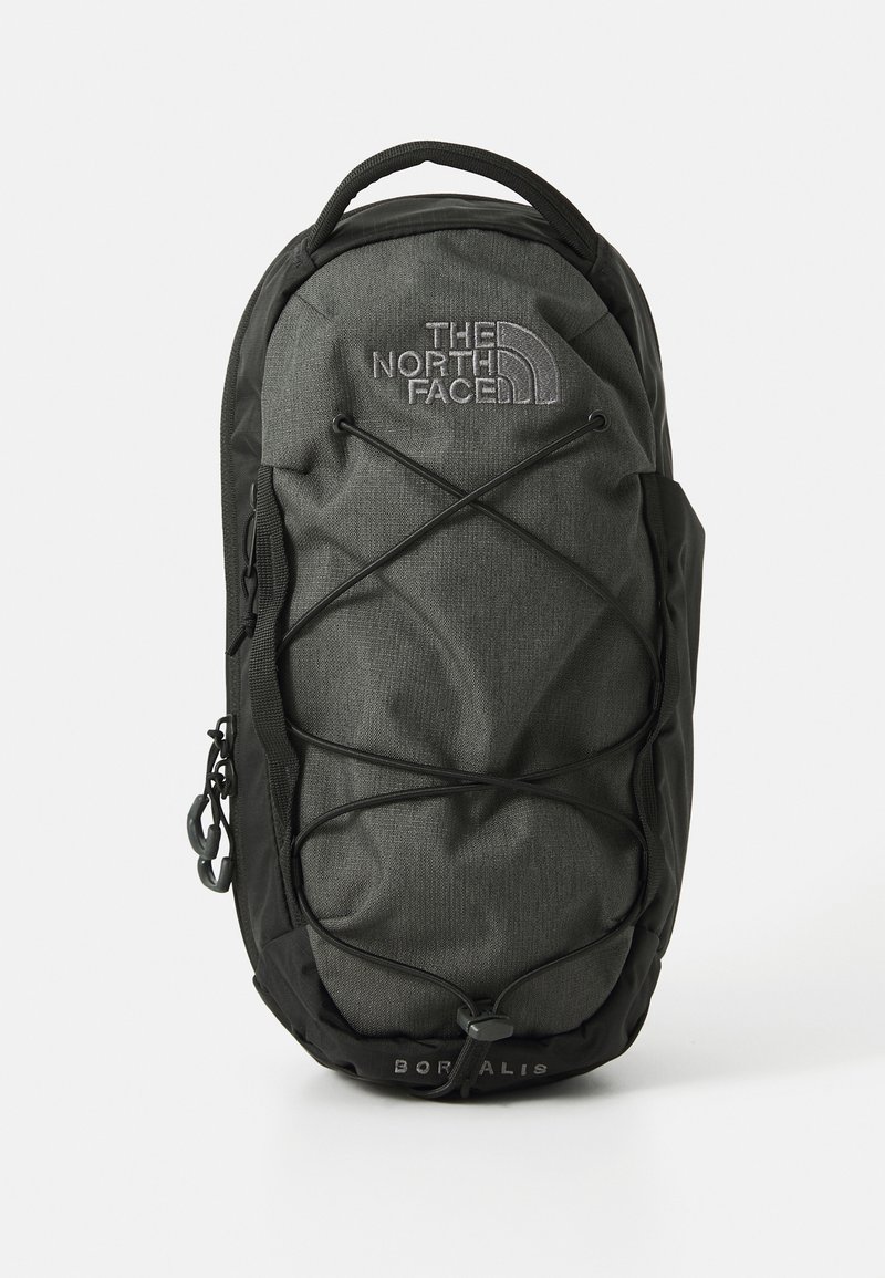 Rucsac gri închis cu accente negre, din material textil, cu un design cu elastic în față, închidere cu fermoar și detaliu cu logo în partea de sus.