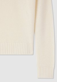 Sweter z dzianiny w kolorze kremowym, z teksturalnym, prążkowanym wzorem na mankietach i dolnej krawędzi. Miękki, średniej grubości materiał o luźnym splocie.