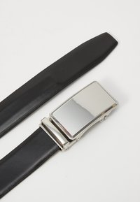 Ceinture en cuir noir avec une boucle rectangulaire en argent brillant, dotée d'une surface plate et d'un fermoir latéral, affichant une texture lisse et un design épuré.