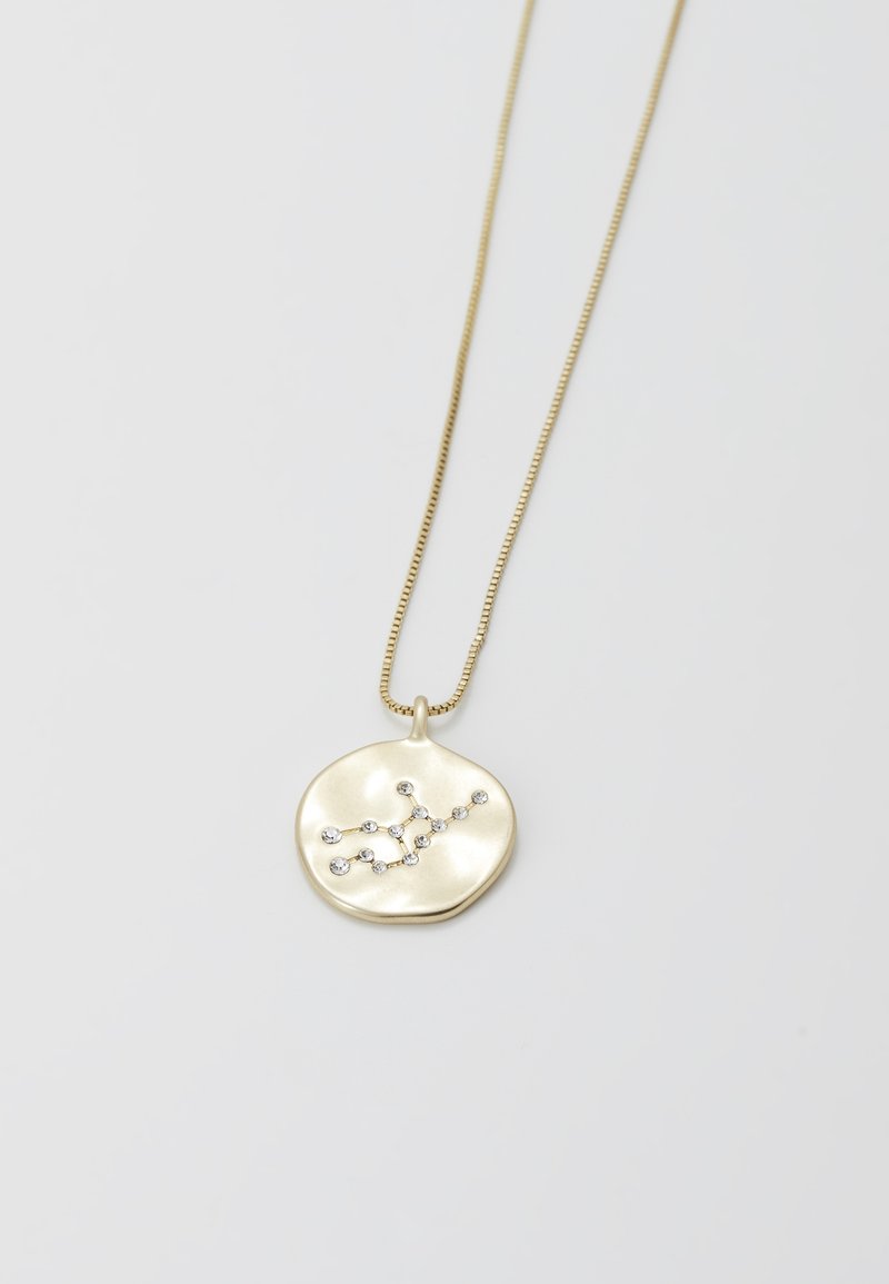 Collar en tono dorado con un colgante redondo y texturizado que presenta un diseño de constelación adornado con pequeñas piedras preciosas.
