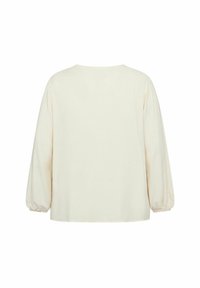 Blusa cremosa a maniche lunghe con scollatura rotonda, vestibilità ampia e polsini arricciati. Tessuto morbido con una superficie liscia e design minimale.