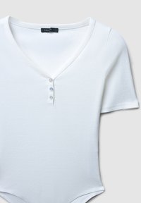 Body bianco a costine con scollo a V, maniche corte e tre bottoni sul davanti. Tessuto morbido e design aderente.
