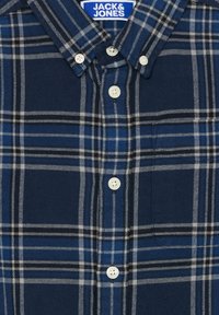Modrá a čierna károvaná košeľa s bielymi gombíkmi a štítkom Jack & Jones na vnútornej strane goliera.