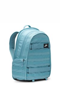 Blå nylon rygsæk med en rund top, flere lynlåslommer og en tekstureret front med vandret webbing. Nike-logo vist.