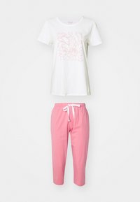 Maglietta bianca in cotone con un design floreale rosa, abbinata a pantaloni joggers rosa a girocoscia con vita elasticizzata e cordoncino bianco.