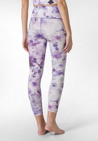 Lila blommönstrade leggings med hög midja, tillverkade av mjukt, stretchigt material. Har sömdetaljer och ankel-lång längd.