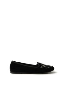 Zapato plano de terciopelo negro con diseño bordado de abeja, punta redondeada, ribete elástico y textura suave. Tacón bajo con suela delgada.