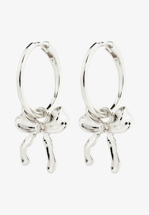 Srebrne kolczyki na kółku z kokardką na środku, prezentujące polerowane wykończenie i gładką fakturę.