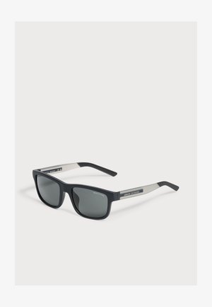 Schwarze und graue rechteckige Armani Exchange Sonnenbrille mit dunklen Gläsern auf weißem Hintergrund.
