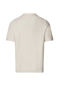 Camisa polo de manga corta en color crema con una tela texturizada, que presenta un cuello clásico y un dobladillo recto, vista desde atrás.