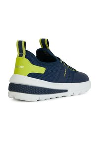 Zapatillas deportivas azul marino con upper de malla transpirable, acentos en verde lima, suela de goma texturizada y tiradores para facilitar el calzado.