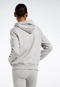 Felpa grigia con cappuccio, dal tessuto morbido, dal taglio casual e con polsini e orlo a coste. Il design include un cappuccio per maggiore calore e comfort.