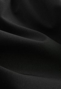 Svart tyg med en jämn textur, med mjuka draperingar och en subtil lyster, idealiskt för olika klädesapplikationer.