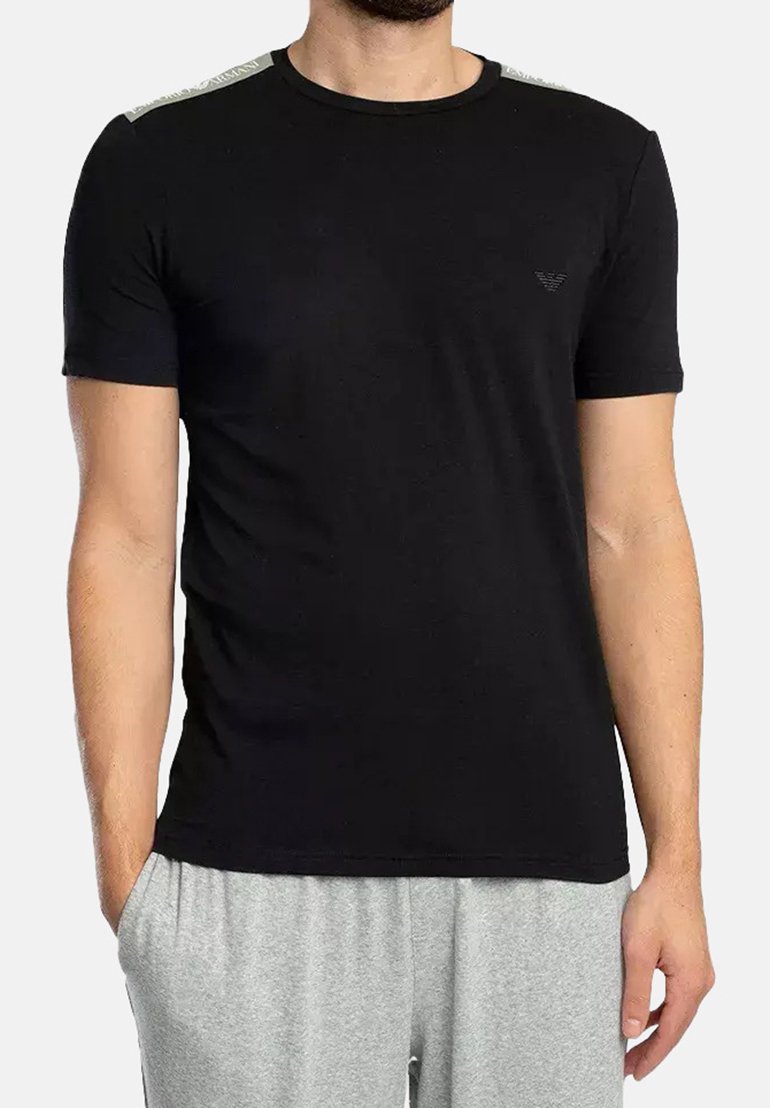 T-shirt noir à manches courtes avec des accents gris sur les épaules. Fabriqué en tissu doux, il présente un logo discret au niveau de la poitrine.