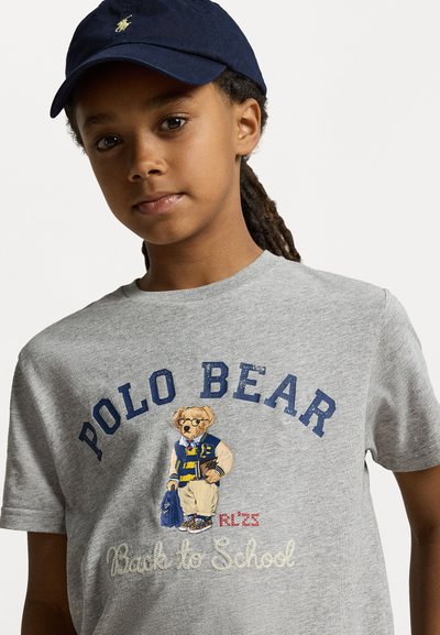 Siva bombažna majica s kratkimi rokavi, ki ima izšito medvedko v univerzitetni jakni in nahrbtniku, z napisom "POLO BEAR" in "Nazaj v šolo" v mornarsko modri barvi.