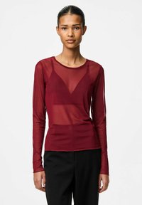 Burgundy långärmad genomskinlig topp med en figursydd design och V-ringning, lager på en fast underlayer. Har ett strukturerat, lätt tyg.