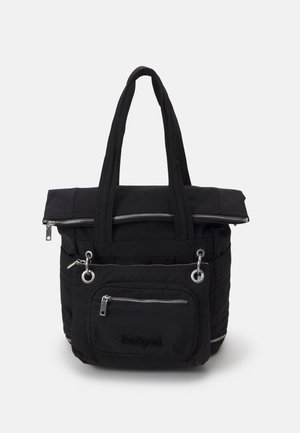 Sac cabas noir avec doubles poignées supérieures, poche zippée avant avec anneaux métalliques, et rabat supérieur avec fermeture éclair visible.
