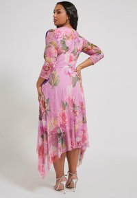 Vaaleanpunainen kukkakuosis maxi-mekko, jossa on läpinäkyvä kangas, kolmanneksen pituiset hihat ja korkea-matala helma. Korostettuna eloisilla ruusukuosisilla ja herkillä nappilistoilla.