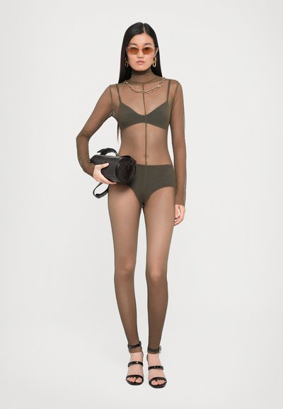 Olivroheline võrgust bodysuit pika varrukaga, kõrge kaelusega ja kettdetailidega. Mudel hoiab musta tekstuuriga käekotti ja kannab musti nöörkõrge kontsaga kingi.