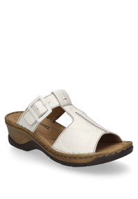 White leather slide sandal with open toe and cut-out design, featuring a buckle accent and brown textured sole.