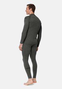 Harmaa pitkähihainen termopaita ja siihen sopivat legginsit, jotka on valmistettu teksturoidusta kankaasta. Mukana logo olkapäässä ja alhaalla jalassa, muotoiltu malli.