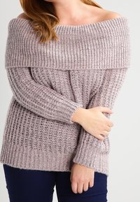 Schulterfreier, gerippter Pullover in hellem Mauve mit langen Ärmeln und lockerer Passform, aus strukturiertem Strickmaterial gefertigt.