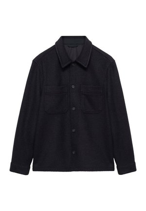 Musta villane overshirt, jossa on terävä kaulus, nappilista ja kaksi rintataskua. Pitkät hihat käännetyin hihansuukin, pehmeä tekstuuri.