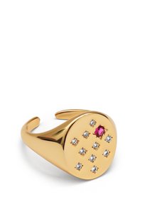 Złoty pierścień na nadgarstek z zaokrągloną powierzchnią, ozdobiony wieloma przezroczystymi kamieniami oraz centralnym różowym kamieniem, o gładkiej fakturze i wypolerowanym wykończeniu.