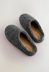 Grå uldsandaler med et struktureret mønster, der har et slip-on design og en faux lædersål; den indre beklædning er beige. Mærkenavnet er synligt indeni.