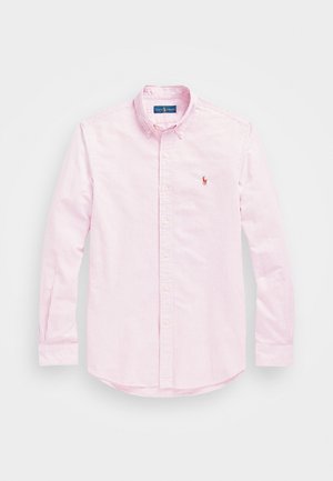 Růžovo-bíle pruhovaná košile na knoflíky s dlouhými rukávy, klasickým límcem a malým vyšitým logem na levé straně hrudi. Bavlněná látka.