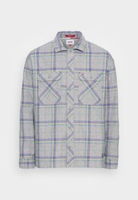 Camicia a maniche lunghe a quadri grigia con strisce blu e gialle, chiusura frontale con bottoni, due tasche sul petto con bottoni e un piccolo logo Tommy Jeans.