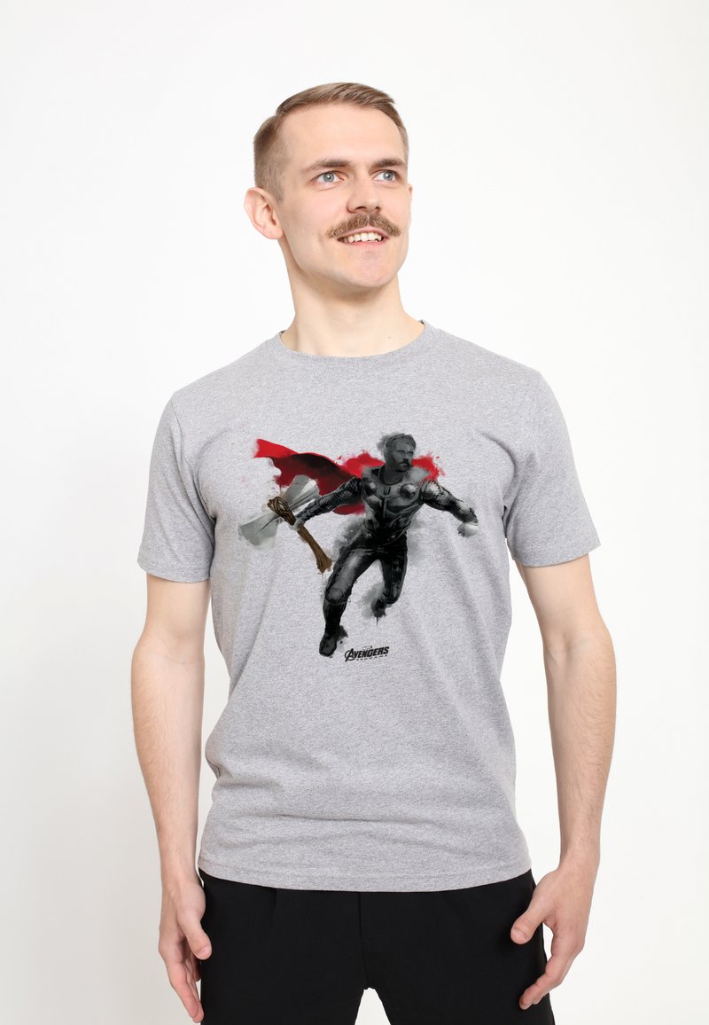Camiseta de algodón gris con un gráfico de un personaje con armadura, llevando una capa roja y sosteniendo un hacha, con el texto "Avengers" en la parte inferior.