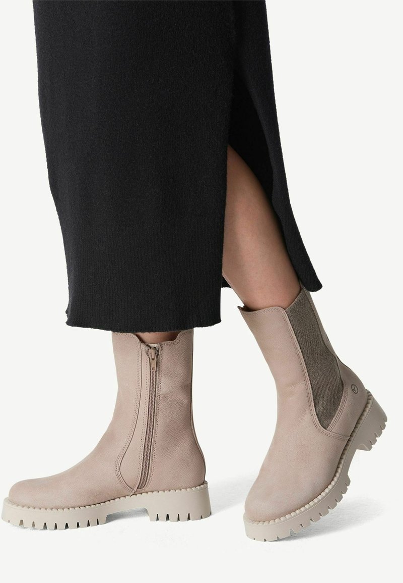 Beige enkellaarzen met een zijrits, elastische panelen en een gestructureerde zool. Het ontwerp heeft een slanke silhouette en een minimalistische esthetiek.