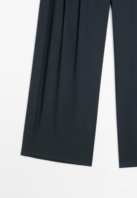 Weite Hosen in dunkelblauem Stoff. Mit plissiertem Design, glatter Textur und geradem Schnitt von der Taille bis zum Saum. Keine sichtbaren Beschläge.