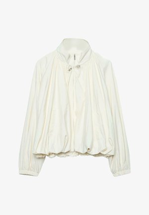 Bijela lagana jakna s visokim ovratnikom, patentnim zatvaračem sprijeda, vezicama na vratu, elastičnim manšetama i skupljenim rubom.