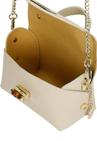 Beige Lederhandtasche mit strukturiertem Design, goldenen Beschlägen und einem Innenfutter in goldgelb. Verfügt über einen auffälligen Verschluss und einen Kettenriemen.