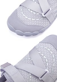 Helle lila Sportschuhe mit einem Mesh-Obermaterial, strukturierten Mustern und verstellbaren Riemen. Flexible Gummisohle mit einem hexagonalem Design.