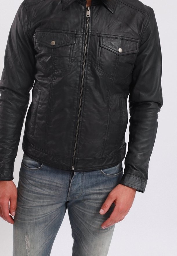 Černá kožená bunda se zipem vpředu, dvěma náprsními kapsami a strukturovaným límcem. Nositá přes světle modré vybledlé džíny.