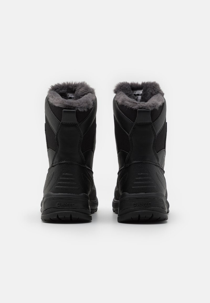 Botas impermeables negras con forro de pelo sintético, que cuentan con una suela de goma texturizada, talón reforzado y altura hasta el tobillo para mayor soporte.