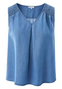 Džínově modrý top bez rukávů s výstřihem do V, zdobený na ramenou nařasením a volným, splývavým střihem. Měkká textura.