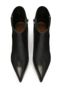 Botas de cuero negro hasta el tobillo con punta afilada, con cremalleras laterales y una textura suave. Incluye un diseño simple y elegante.