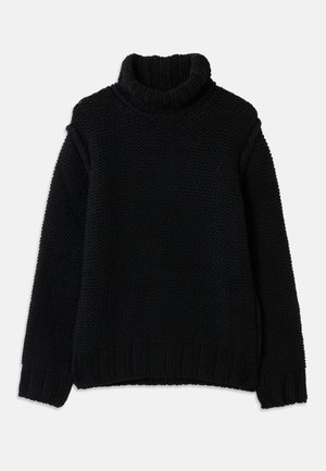 Pull en laine noir avec col roulé haut, présentant un motif texturé, des poignets et un ourlet côtelés. Coupe ample avec des épaules tombantes.