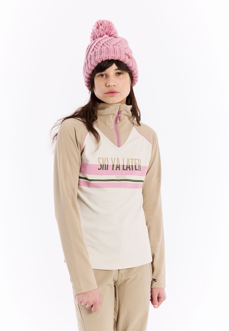 Crème langemouwen top met beige accenten en een roze horizontale streep met tekst. Een roze gebreide beanie met een pompon.