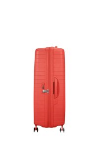 Valigia rigida rossa con design a righe verticali, una maniglia laterale, chiusura con zip e quattro ruote girevoli per la mobilità.