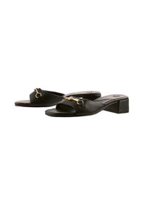 Zwarte leren blockhak sandalen met een open teen, gekruiste bandjes en accenten van goudkleurig metaal. Soepele textuur met een minimalist ontwerp.