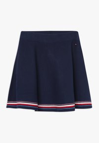 Marineblå, flagrende nederdel med ribbet talje og røde, hvide, blå og rosa vandrette striber nær kanten.