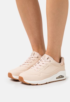 Baskets rose clair avec une tige en synthétique lisse, des détails perforés, une semelle blanche et un crampon en caoutchouc marron. Conception à lacets avec un logo.